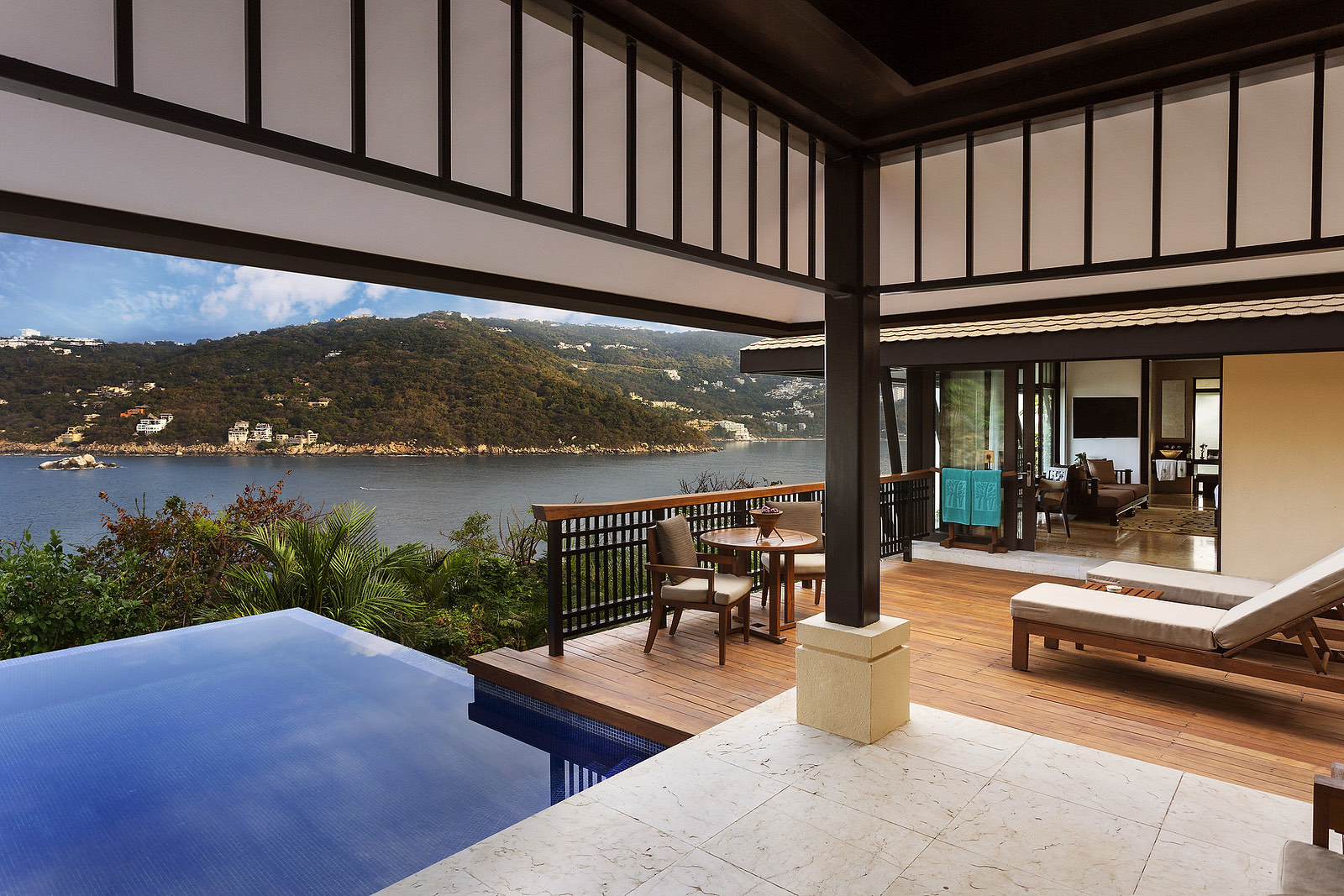 Terraza de villa con alberca infinita frente a la bahía