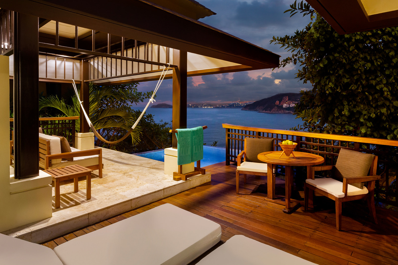 Terraza con hamaca, alberca privada y comedor al atardecer