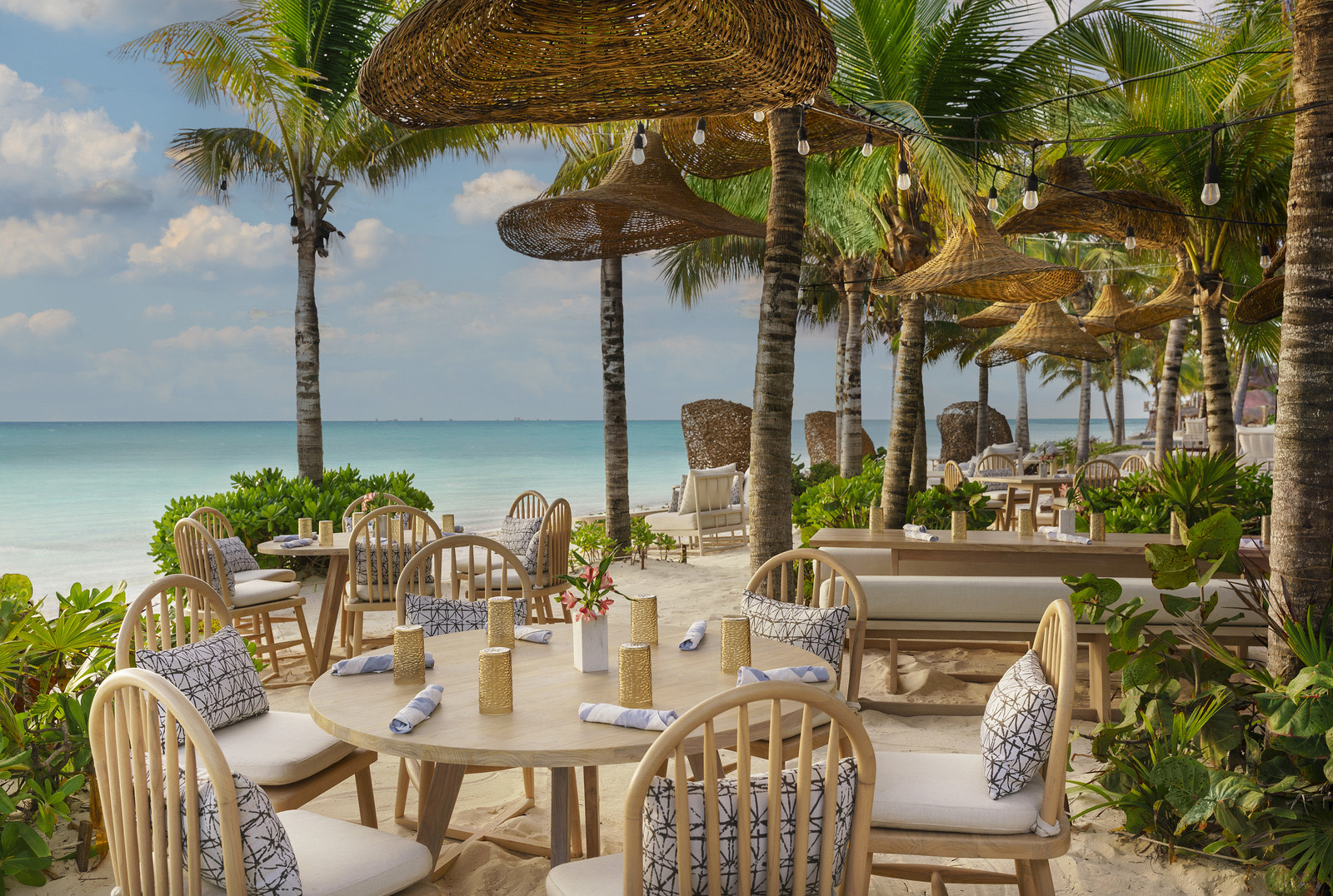 Restaurante de playa bajo palapas y palmeras