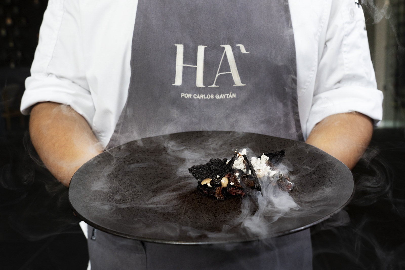 Chef presentando un postre con humo