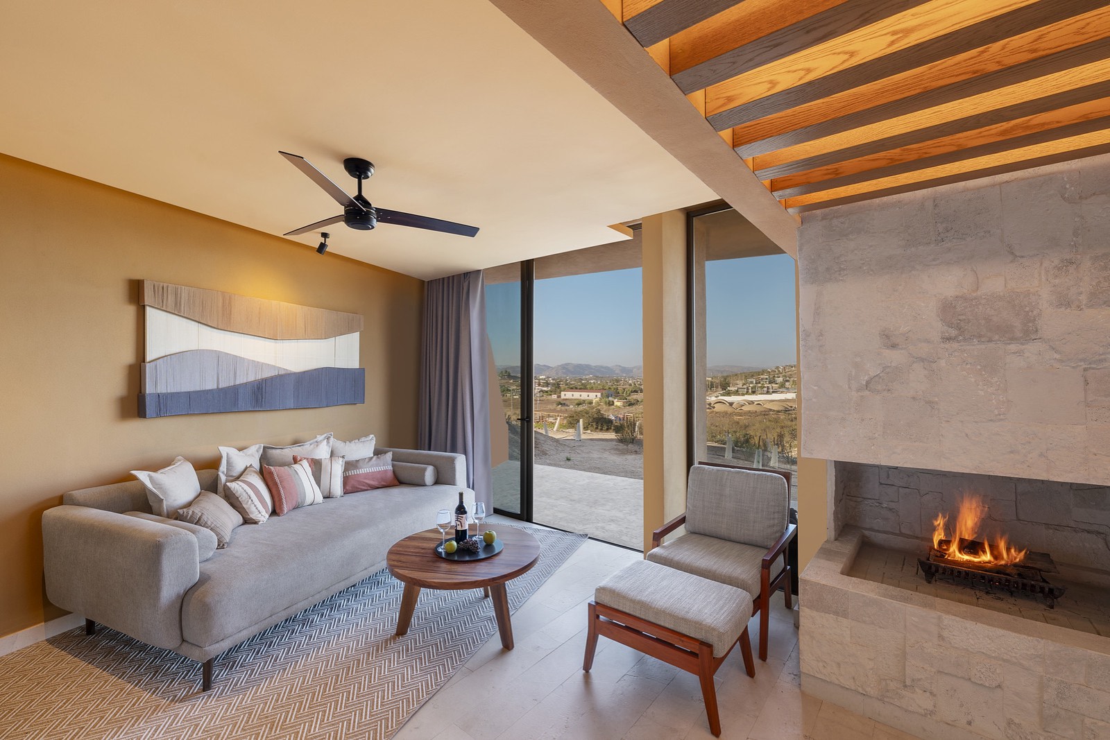 Sala de suite con chimenea encendida y vista al valle