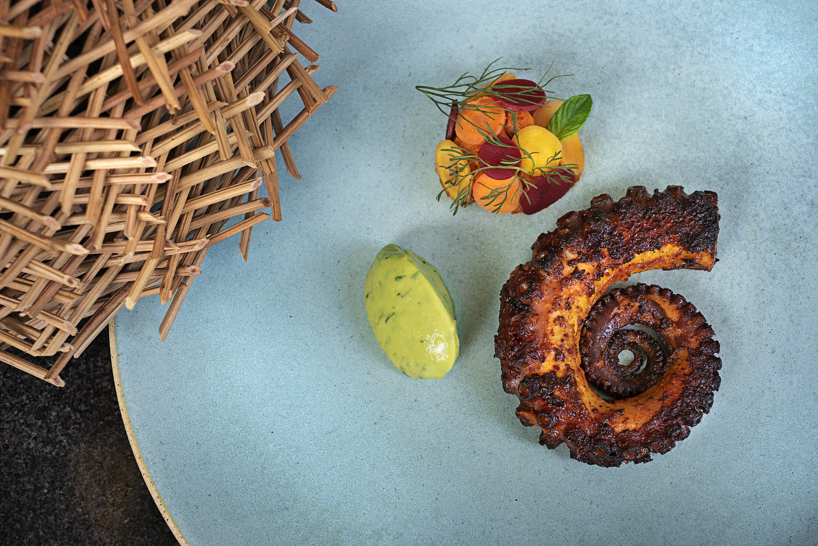 Pulpo a las brasas en plato turquesa