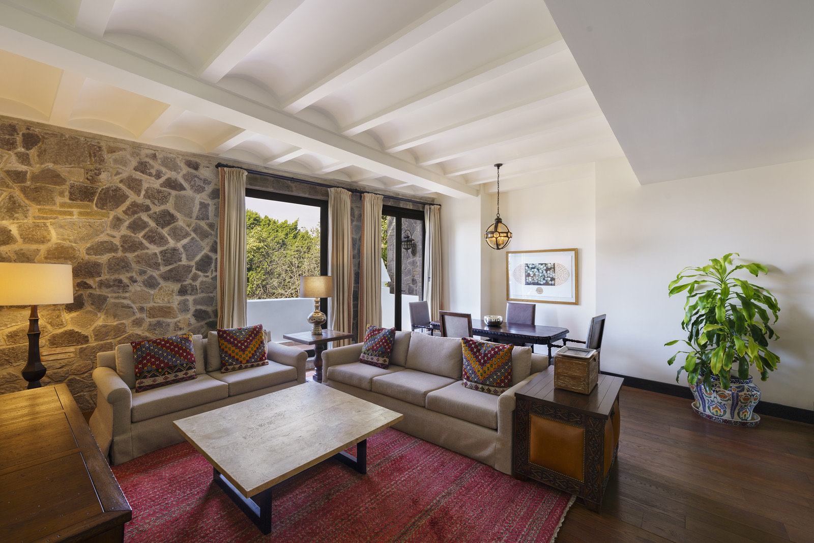 Sala de suite con muro de piedra y tapetes artesanales