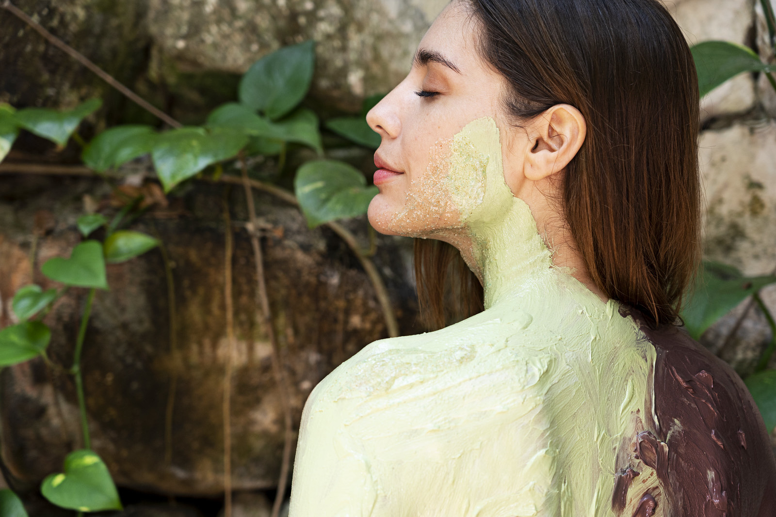 Huésped con mascarilla de arcilla verde entre plantas