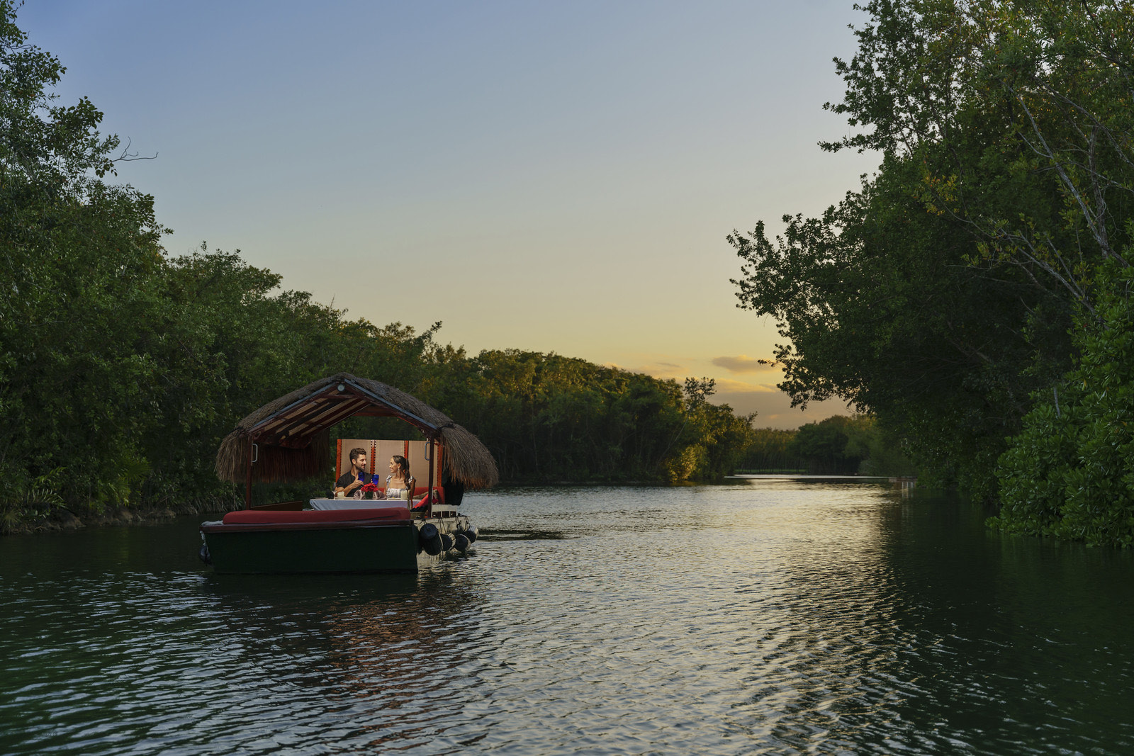 Lancha en los canales de manglar al atardecer