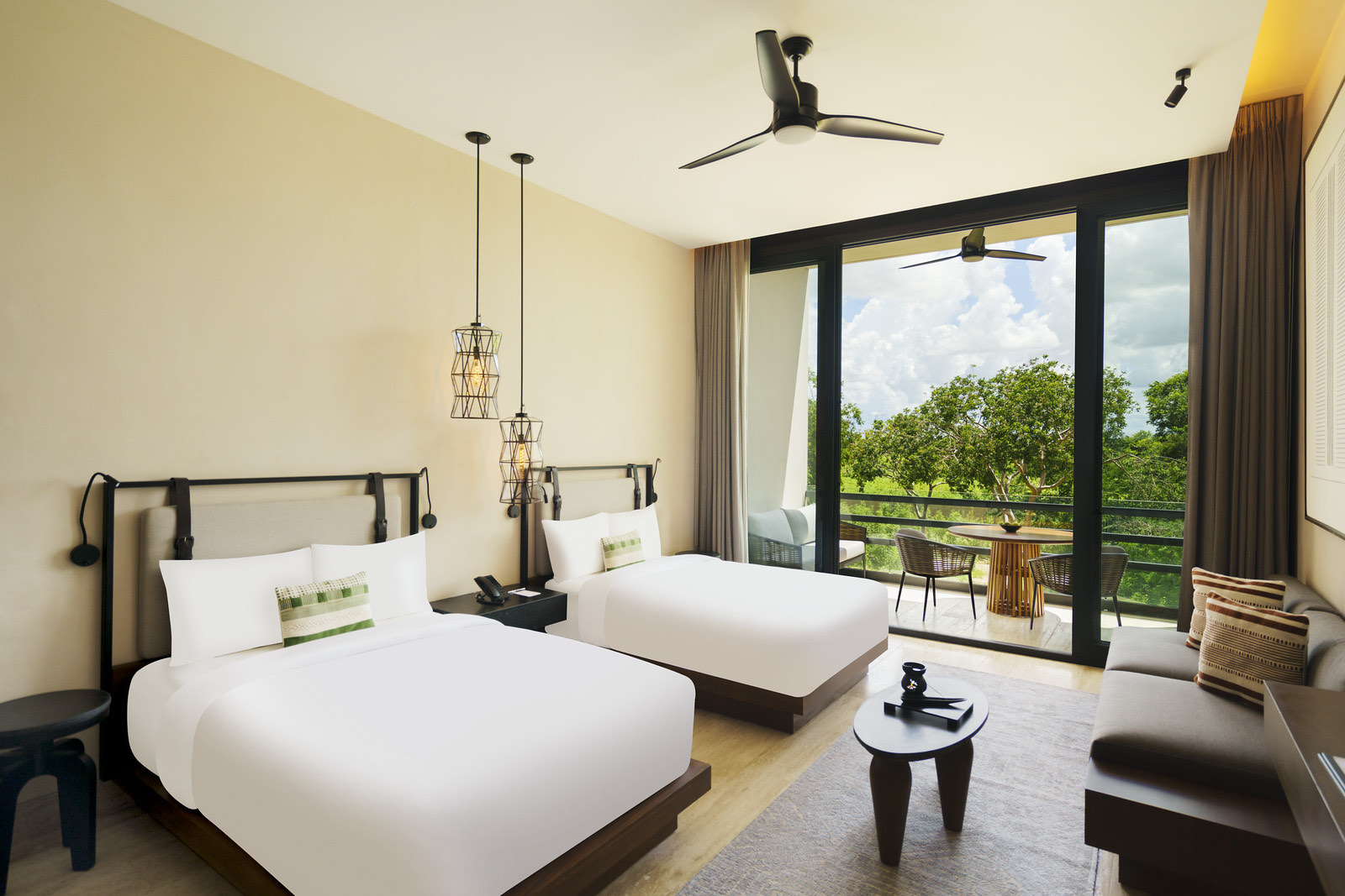 Habitación con dos camas y balcón hacia el jardín
