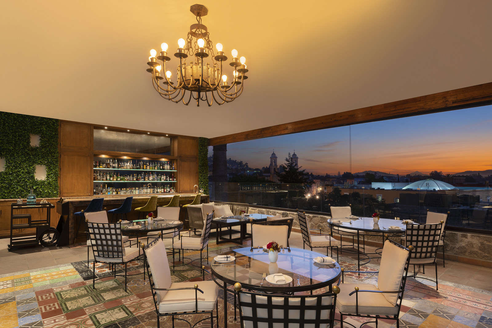 Bar con candelabro y vista a la ciudad al anochecer