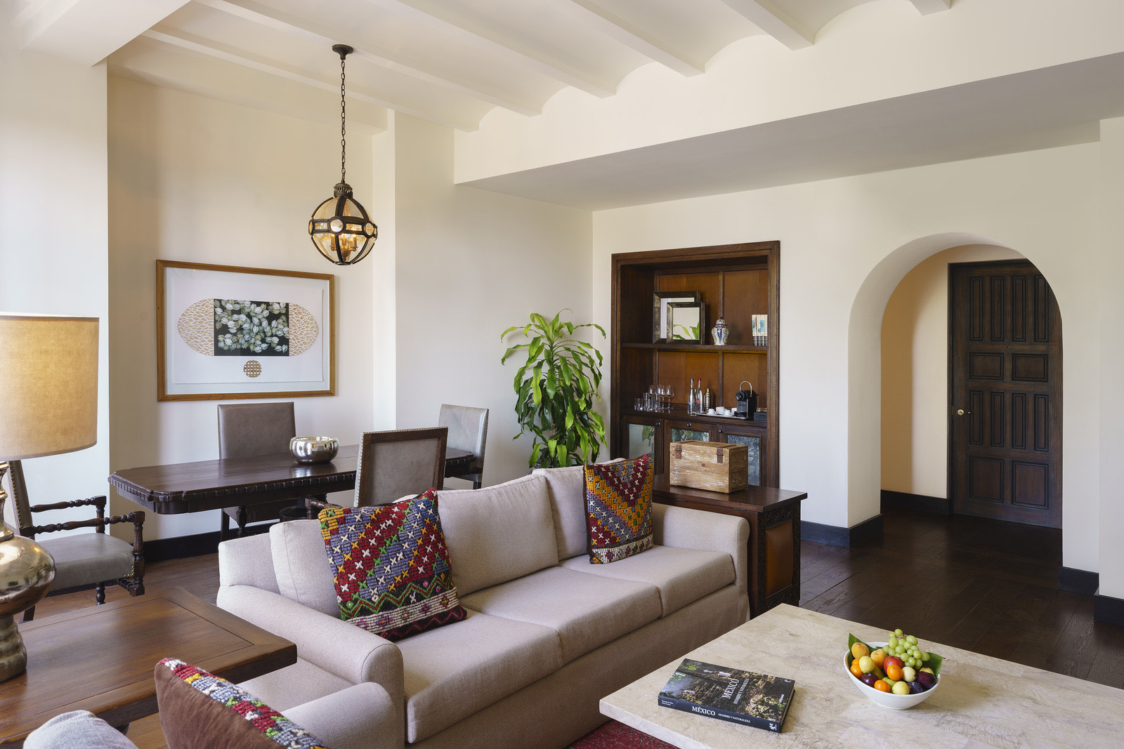 Sala de estar con arcos coloniales y textiles bordados