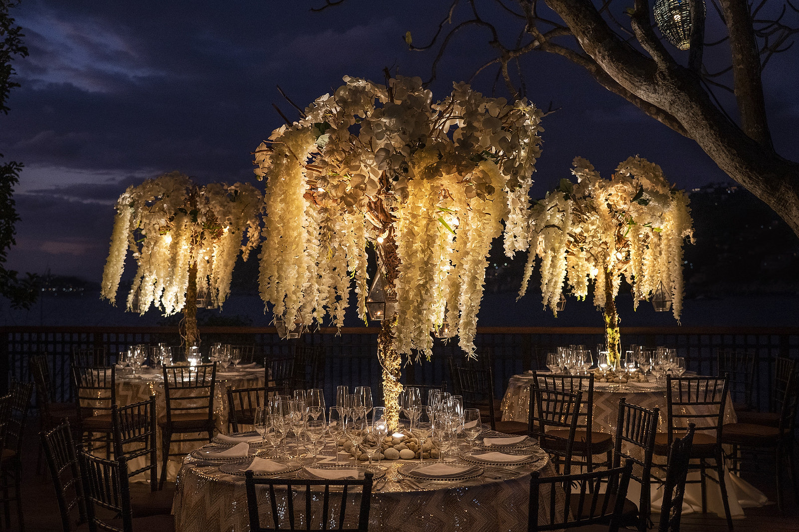 Cena de gala bajo centros de mesa florales iluminados